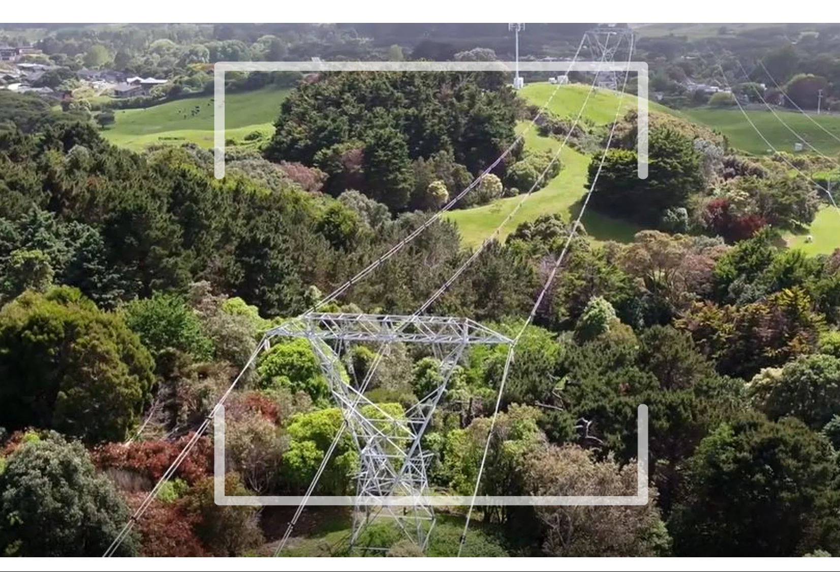 Power transmission infrastructure crossing a green landscape, illustrating the Omexom Green Stories campaign